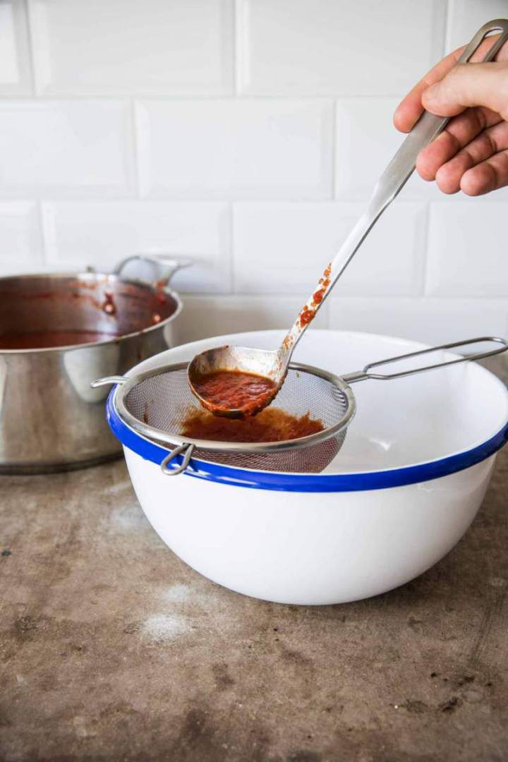 Straining Homemade Simple Tomato Purée through a sieve | jernejkitchen.com