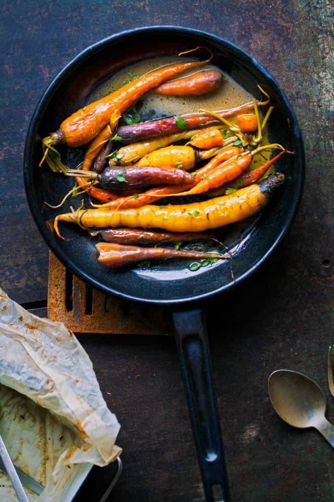 Braised carrots in a pan with herbs