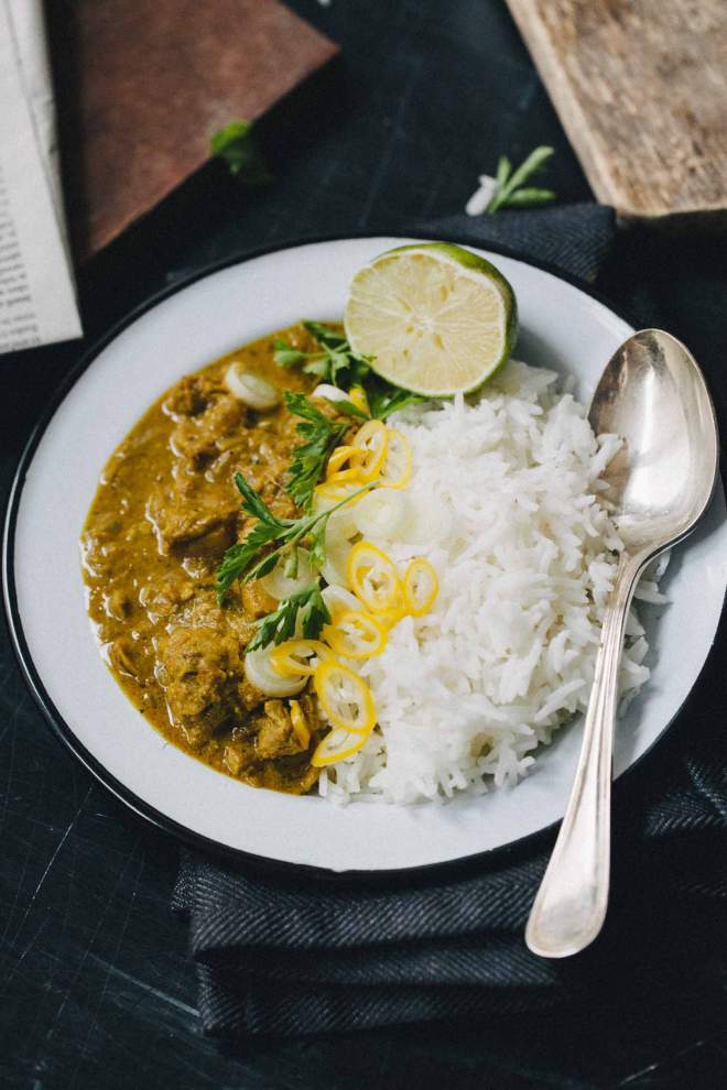 Chicken korma served with rice and coriander on the plate