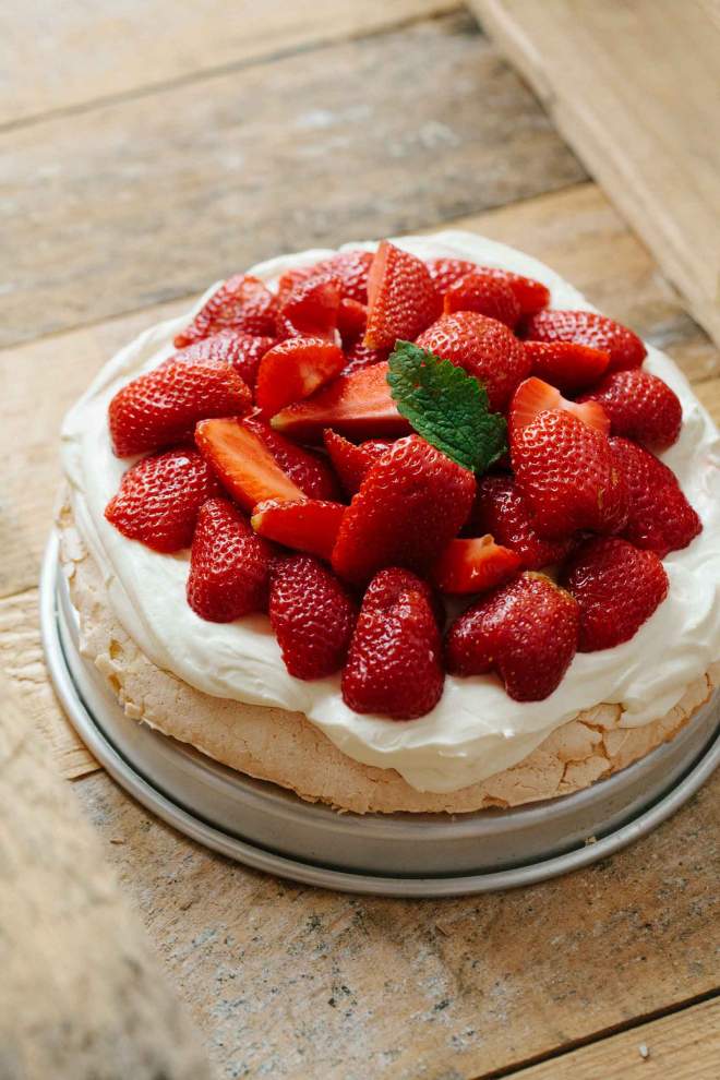 Pavlova with strawberries and cream served on a plate