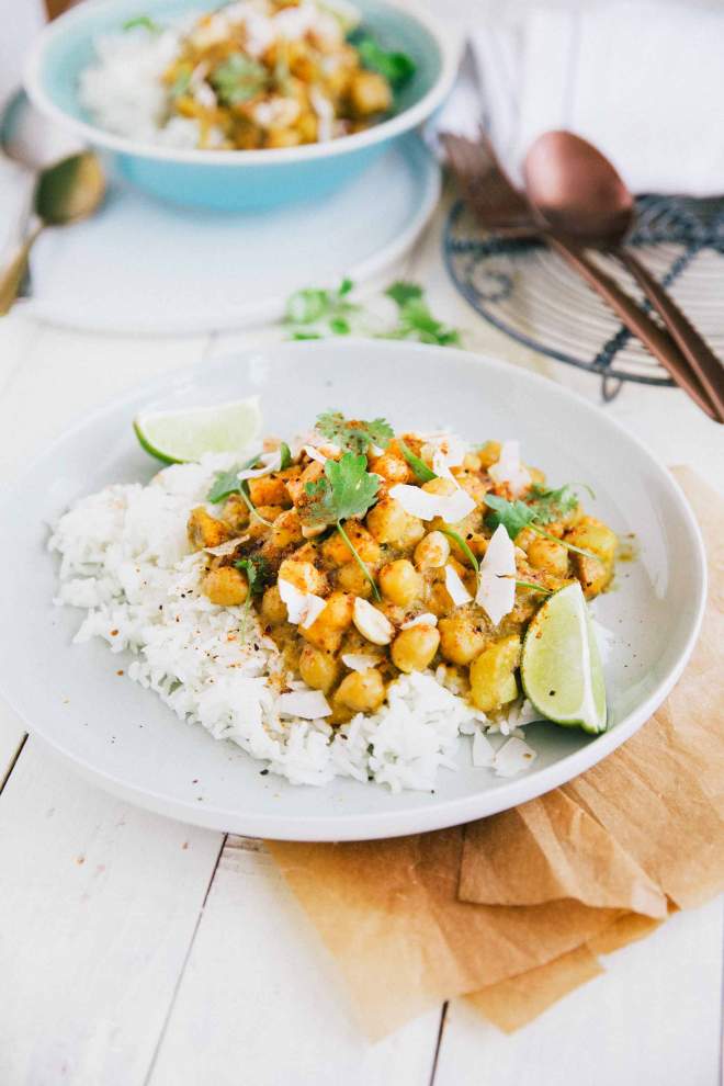 Curry iz sladkega krompirja in čičerike postrežene z rižem in kokosom