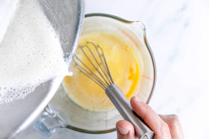 boiling milk pouring over eggs for Blackberry Mousse with Rosemary Crumble