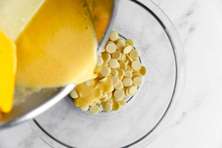 Pouring cream over white chocolate for Blackberry Mousse with Rosemary Crumble