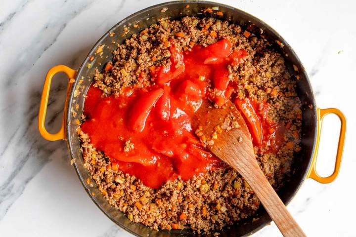 adding tomatoes to Easy Bolognese