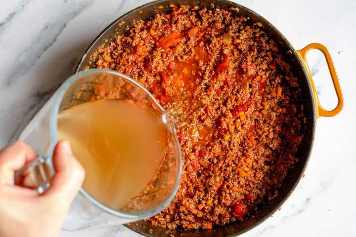 adding beef stock to Easy Bolognese