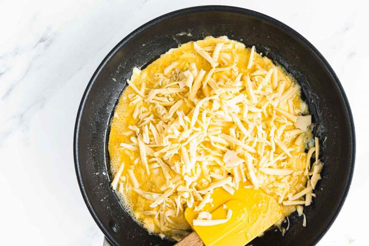 Adding cheese to eggs for homemade Cheesy Scrambled Eggs