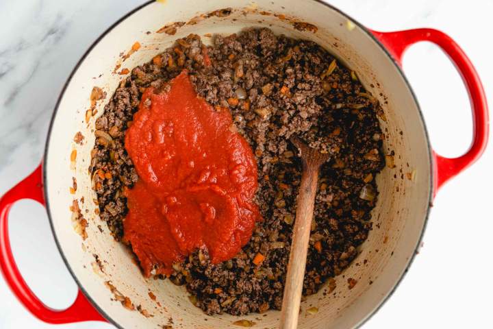 Dodajanje paradižnikove omake za Chili con Carne