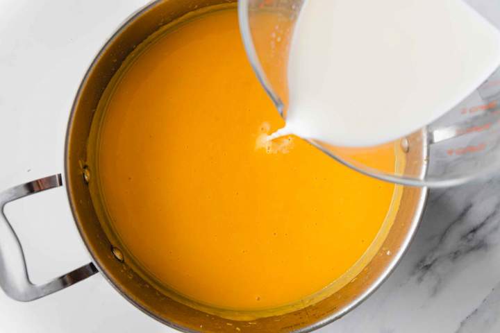 Pouring milk into Creamy Butternut Squash Soup
