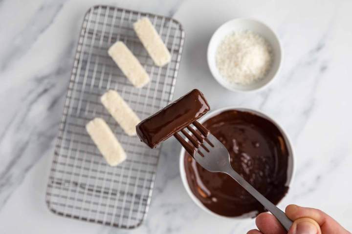 Dipping Coconut Chocolate Bars (No-Bake Bounty) in chocolate