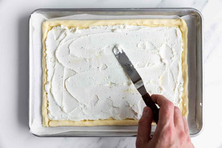 Spreading the ricotta filling on top of the puff pastry