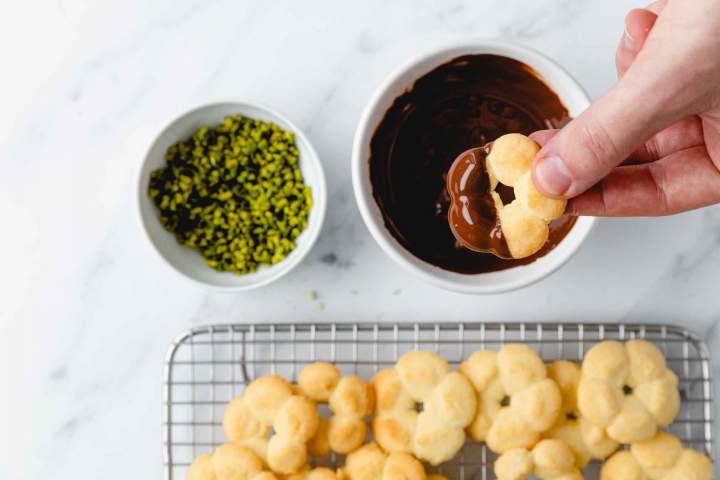 Dipping Spritz cookies in melted chocolate