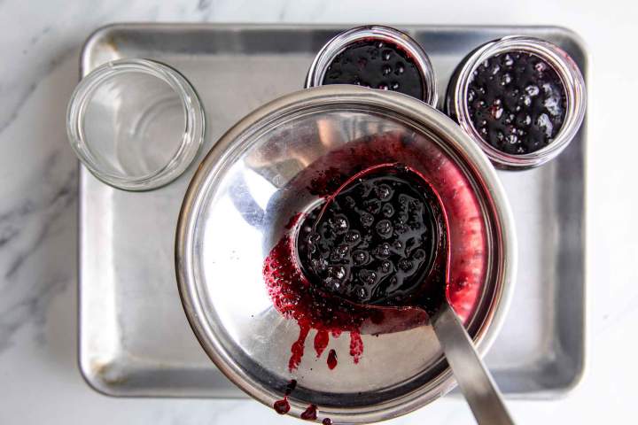 Filling canning jars with Wild Blueberry Jam