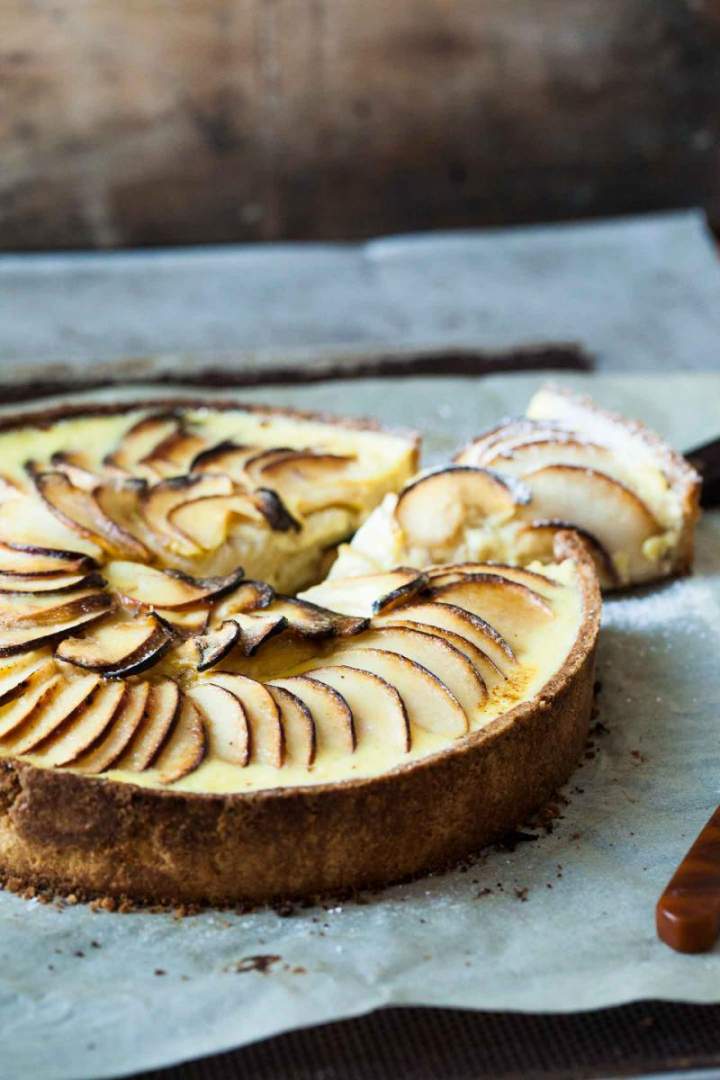 Apple tart with vanilla sauce sprinkled with icing sugar