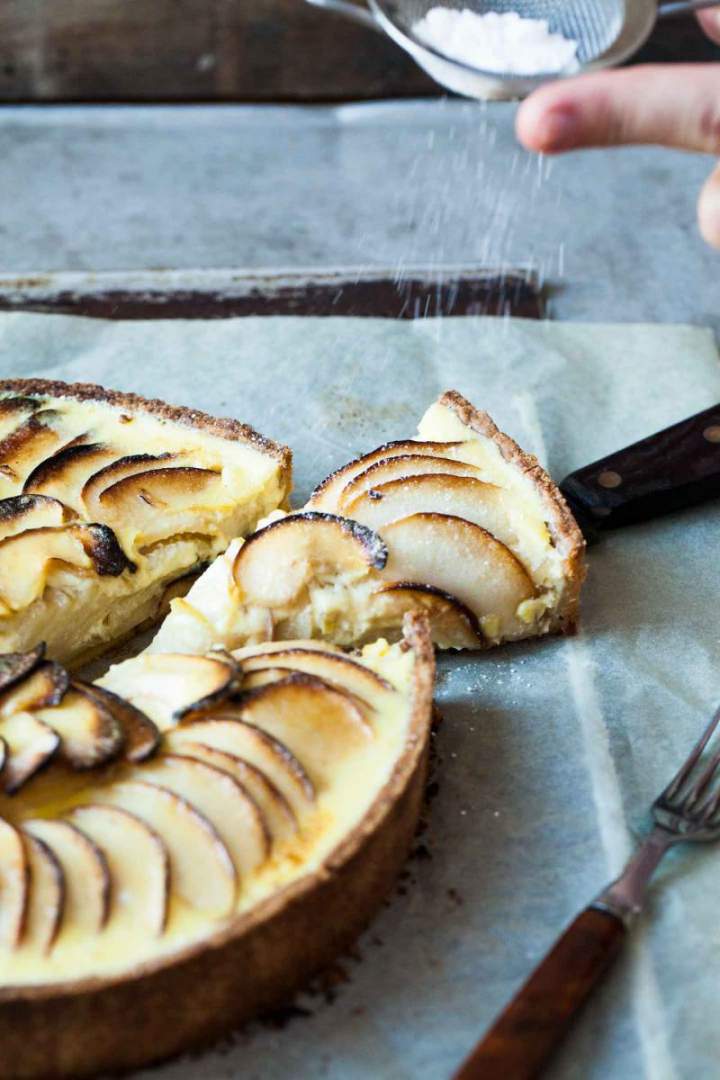 Apple tart with vanilla sauce sprinkled with icing sugar