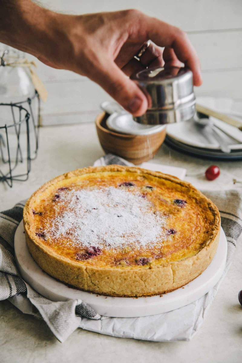 Dusting Cherry Custard Tart with icing sugar