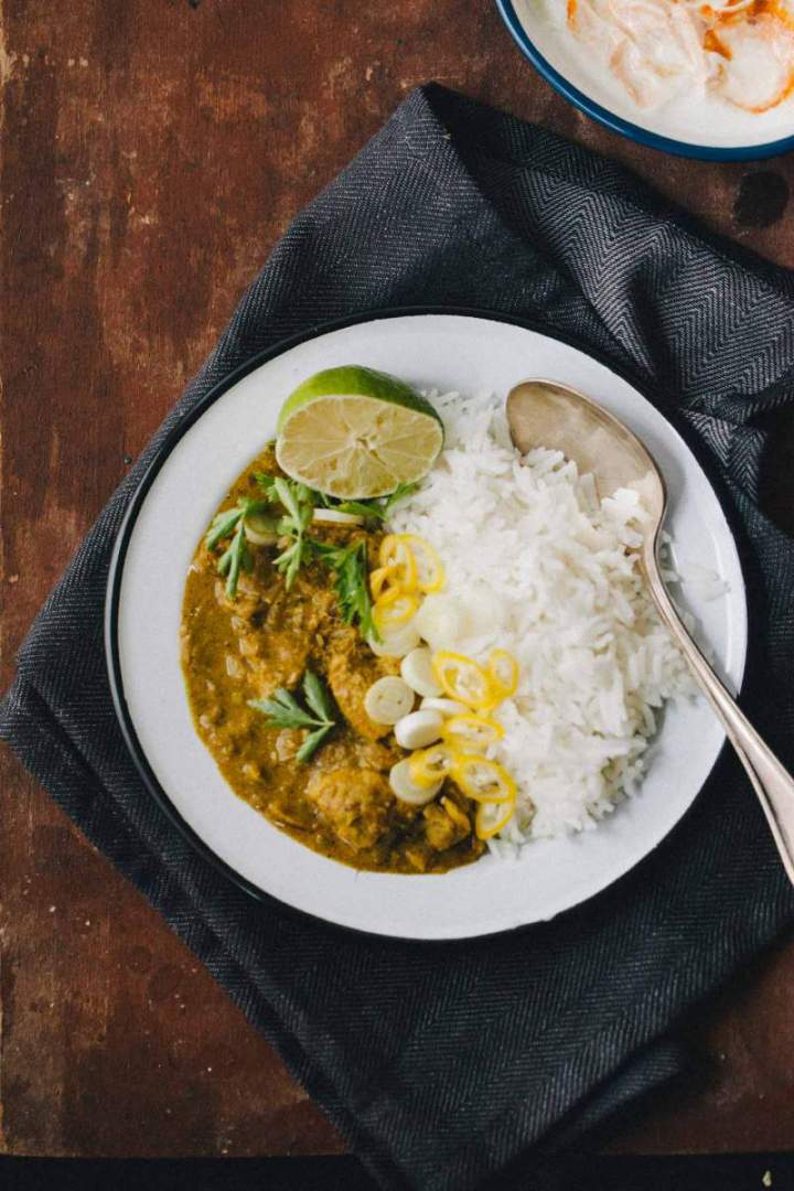 Chicken korma served with rice and coriander on the plate