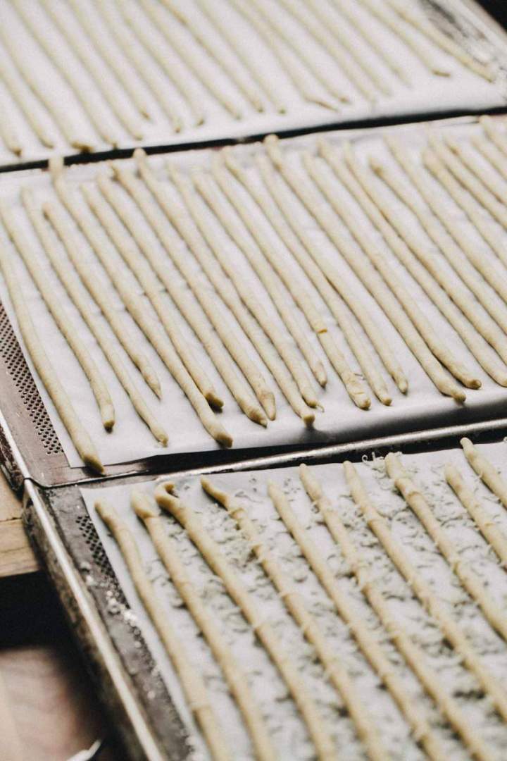 Corn and Parmesan cheese grissini on a baking sheet before baking