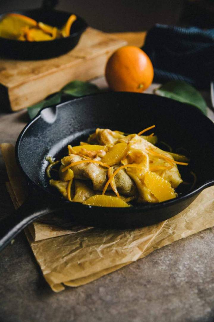 Crêpes with silky orange sauce served in a skillet