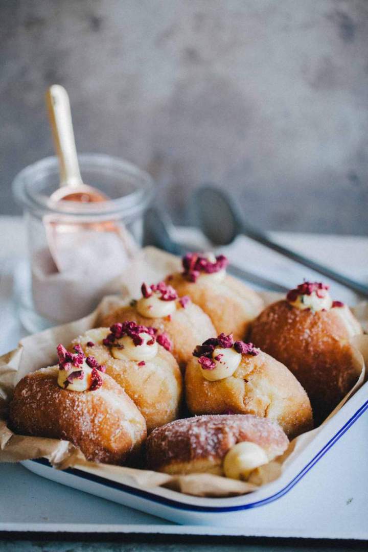 Homemade Brioche Doughnuts with rich vanilla cream and strawberries in a baking dish