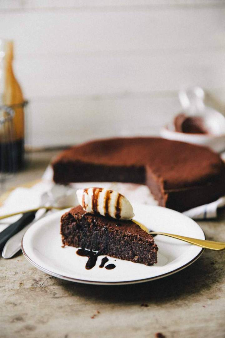 Slice of Flourless espresso chocolate cake served with ice cream and chocolate sauce