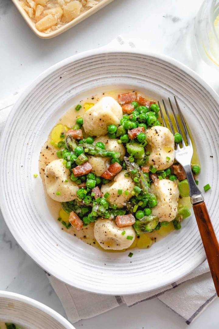 Gnudi z ricotto, šparglji in panceto