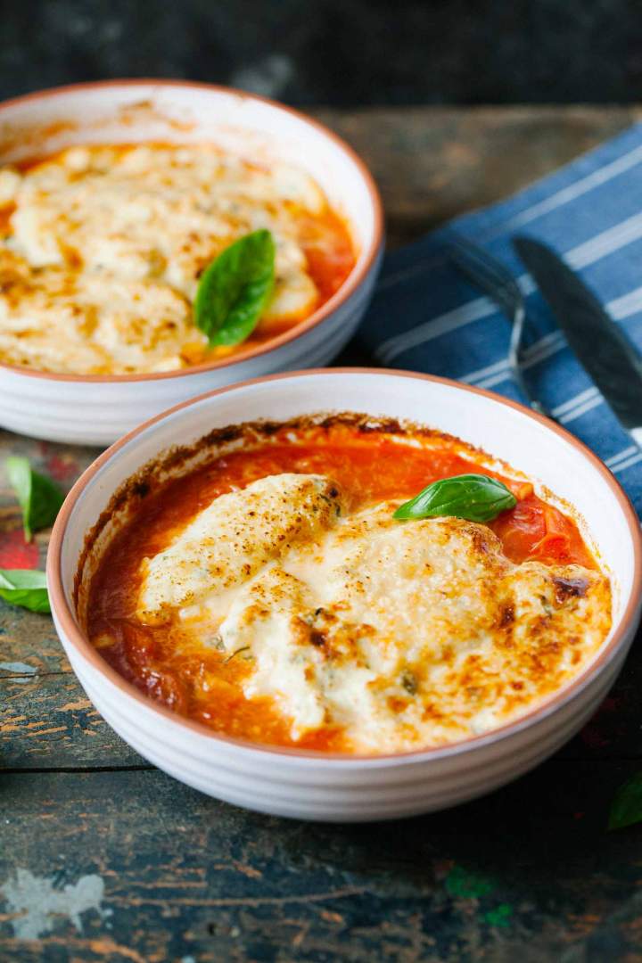 Herb dumplings gratin with tomato sauce served in bowls