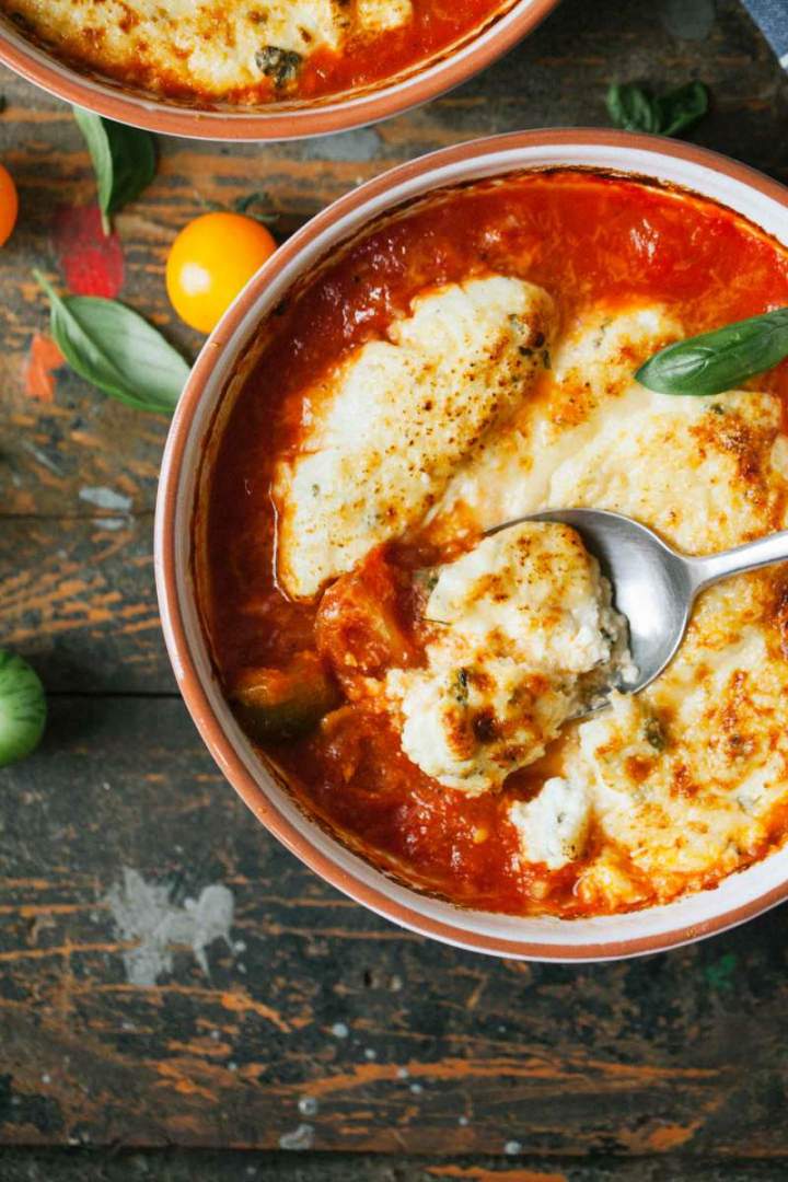 Herb dumplings gratin with tomato sauce and melting cheese