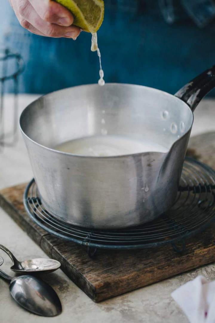 Squeezing lemon juice into a saucepan for Homemade Mascarpone