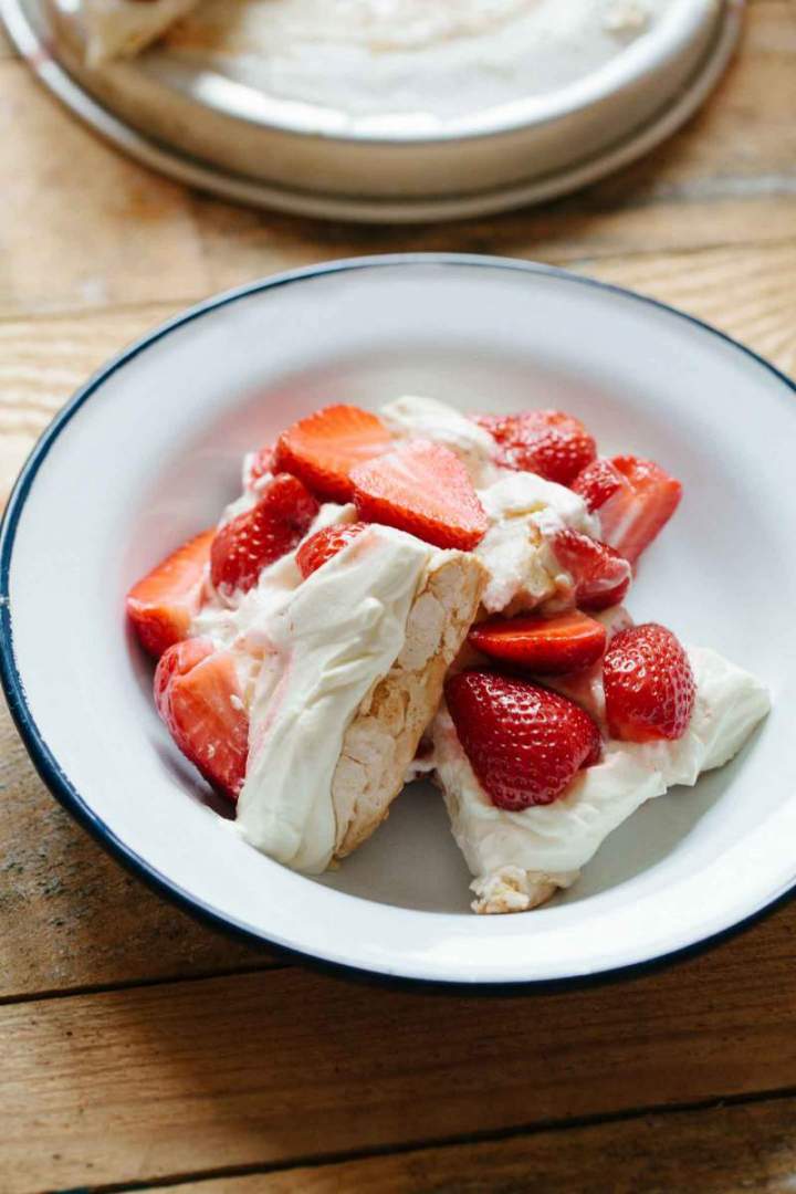 Pavlova with strawberries and cream served on a plate