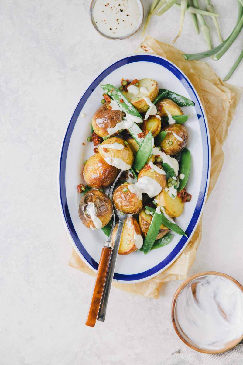 Potato salad with young sweet peas served in a serving dish with homemade salad dressing