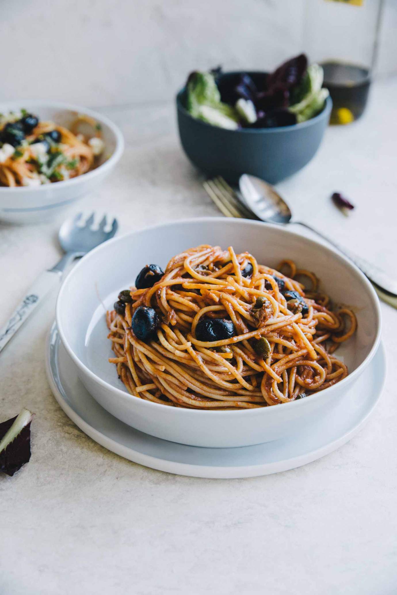 Spaghetti alla Puttanesca served in a bowl with parsley and mozzarella