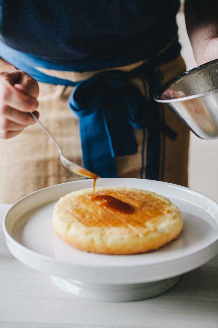 Pouring syrup over baked sponge cake