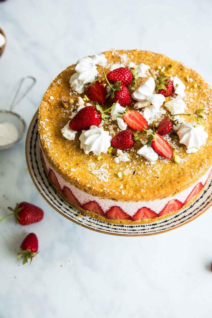 Strawberry Mousse Cake decorated with meringue cookies, icing sugar and fresh strawberries